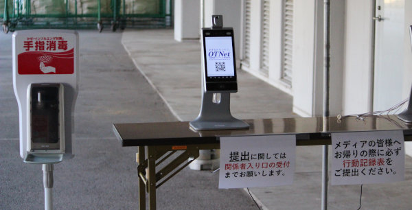 入口前に設置された自動消毒器と検温器